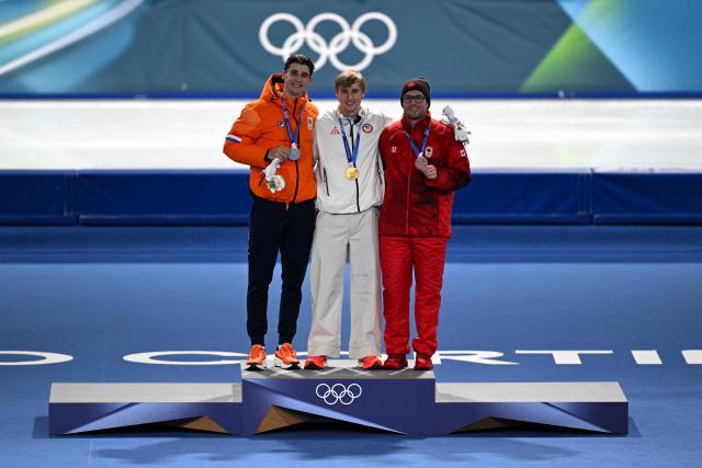 (L-R) Silver medallist Netherlands' Jenning de Boo, gold medallist USA's Jordan Stolz and bronze medallist Canada's Laurent Dubreuil pose on the podium of the speed skating men's 500m during the Milano Cortina 2026 Winter Olympic Games at Milano Speed Skating Stadium in Milan on February 14, 2026. (Photo by Daniel MUNOZ / AFP)