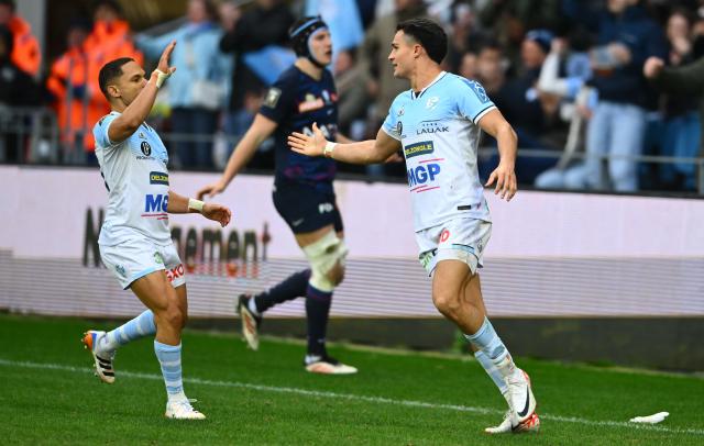 Bayonne's French full-back Tom Spring (R) celebrates with Bayonne's South African scrum-half Herschel Jantjies (L) after scoring Bayonne's fourth try during the French Top14 rugby union match between Aviron Bayonnais (Bayonne) and Racing 92 at the Jean Dauger stadium in Bayonne, south-western France, on February 14, 2026. (Photo by Gaizka IROZ / AFP)
