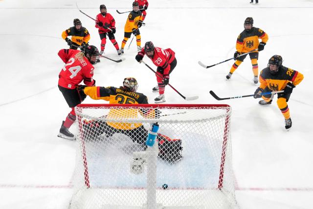 Canada's #29 Marie-Philip Poulin (C) shoots to score her team's fifth goal past Germany's #35 Sandra Abstreiter during the women's quarter final ice hockey match between Canada and Germany at the Milano Rho Ice Hockey Arena at the Milano Cortina 2026 Winter Olympic Games in Milan, on February 14, 2026. (Photo by Darko Bandic / POOL / AFP)
