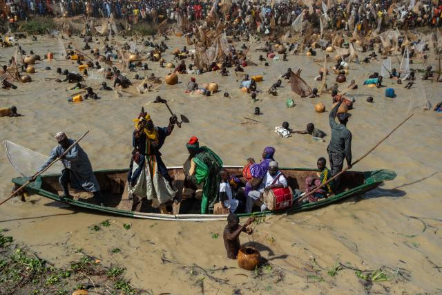 Sarkin Ruwa, the custodian of the Mata Fada river, encourages fishermen as they attempt to catch fish during the Argungu Fishing and Cultural Festival in Argungu Town, Kebbi State in northwest Nigeria, on February 14, 2026. (Photo by TOYIN ADEDOKUN / AFP)