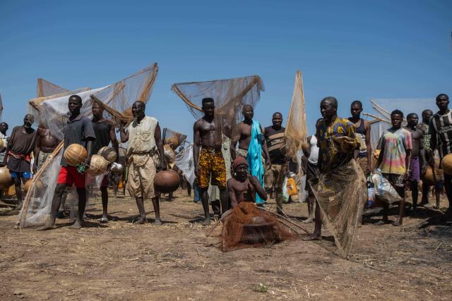 TOPSHOT - Fishermen stand on the bank of the Mata Fada river as they wait to take part in the Argungu Fishing and Cultural Festival in Argungu Town, Kebbi State in northwest Nigeria, on February 14, 2026. (Photo by TOYIN ADEDOKUN / AFP)