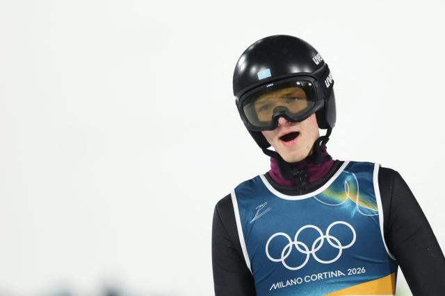 Kazakhstan's Ilya Mizernykh reacts in the finish area after jumping during the 1st round of the men's large hill individual ski jumping of the Milano Cortina 2026 Winter Olympic Games at Predazzo Ski Jumping Stadium in Predazzo (Val di Fiemme), on February 14, 2026. (Photo by Anne-Christine POUJOULAT / AFP)