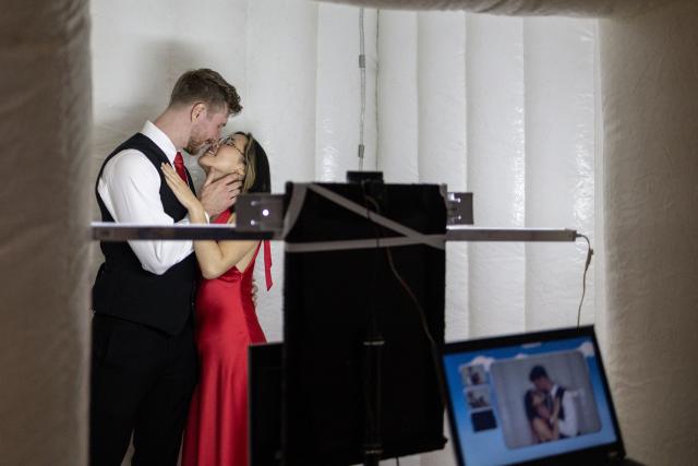 TOPSHOT - Two guests take a souvenir shot during the Chinese New Year Valentine’s Ball hosted by the Chinese Association (TCA) at the Indaba Hotel in Johannesburg, on February 14, 2026. The celebration forms part of the association’s annual cultural program, marking the Lunar New Year with social and community festivities. (Photo by ILARIA FINIZIO / AFP)