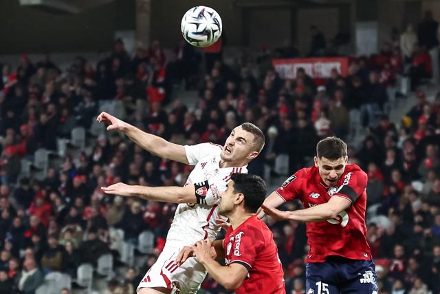 Brest's French defender #05 Brendan Chardonnet (L) eyes the ball next to Lille's French midfielder #21 Benjamin Andre (C) and Lille's French defender #15 Romain Perraud (R) during the French L1 football match between LOSC Lille and Stade Brestois 29 at the Stade Pierre-Mauroy in Villeneuve-d'Ascq, northern France, on February 14, 2026. (Photo by Sameer Al-DOUMY / AFP)