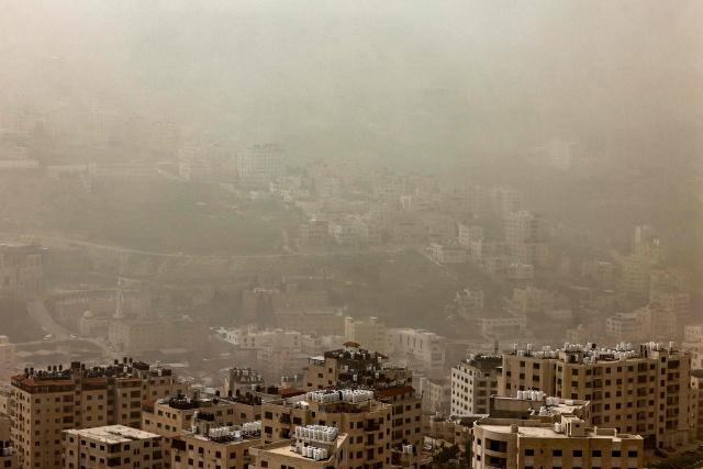 A dust storm engulfs the city of Nablus in the occupied West Bank on February 14, 2026. (Photo by Zain JAAFAR / AFP)