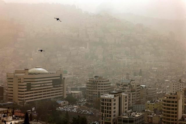 TOPSHOT - A dust storm engulfs the city of Nablus in the occupied West Bank on February 14, 2026. (Photo by Zain JAAFAR / AFP)