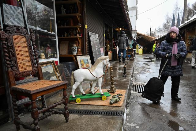 A woman walks through an aisle of the Izmailovo market in Moscow on February 14, 2026. (Photo by HECTOR RETAMAL / AFP)