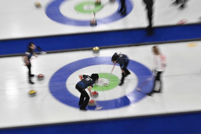 South Korea's Seol Ye-eun (C) sweeps the ice during the curling women's round robin between South Korea and Denmark during the Milano Cortina 2026 Winter Olympic Games at the Cortina Curling Olympic Stadium in Cortina d’Ampezzo on February 14, 2026. (Photo by Tiziana FABI / AFP)