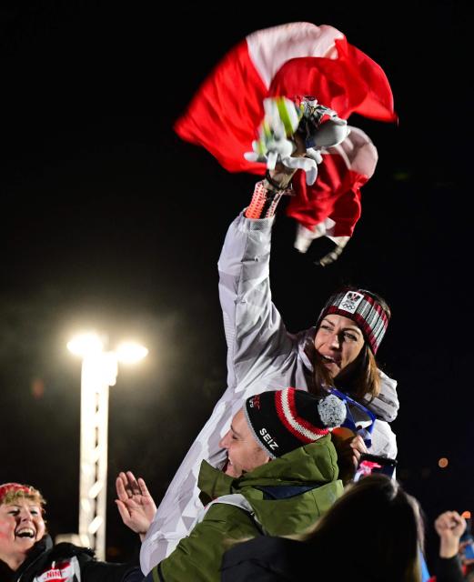 Austria's gold medalist Janine Flock waves a flag after competing in the skeleton women's event at Cortina Sliding Centre during the Milano Cortina 2026 Winter Olympic Games in Cortina d'Ampezzo on February 14, 2026. (Photo by Stefano RELLANDINI / AFP)