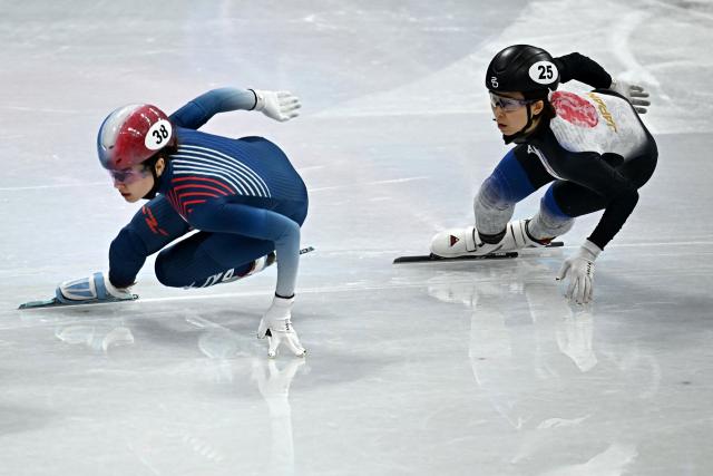 France's Cloe Ollivier (L) and Japan's Ami Hirai compete in the short track speed skating women's 1000m heats during the Milano Cortina 2026 Winter Olympic Games at Milano Ice Skating Arena in Milan on February 14, 2026. (Photo by Gabriel BOUYS / AFP)