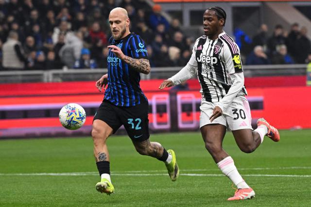 Inter Milan's Italian defender #32 Federico Dimarco fights for the ball with Juventus' Canadian forward #30 Jonathan David during the Italian Serie A football match between Inter Milan and Juventus at the San Siro Stadium in Milan, on February 14, 2026. (Photo by Piero CRUCIATTI / AFP)