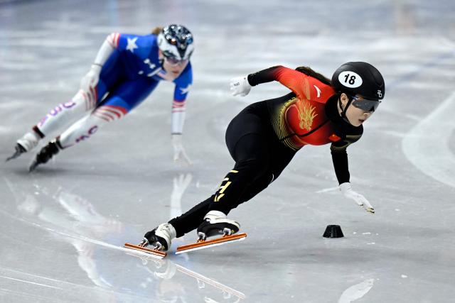 China's Gong Li (R) and USA's Corinne Stoddard compete in the short track speed skating women's 1000m heats during the Milano Cortina 2026 Winter Olympic Games at Milano Ice Skating Arena in Milan on February 14, 2026. (Photo by WANG Zhao / AFP)