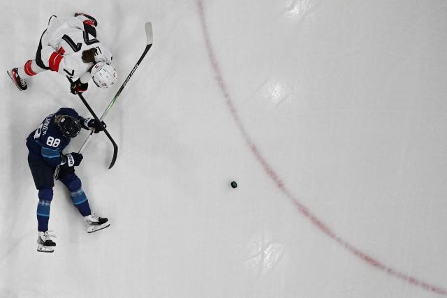 Switzerland's #71 Lena Marie Lutz fights for the puck with Finland's #88 Ronja Savolainen during the women's quarter final ice hockey match between Finland and Switzerland at the Milano Rho Ice Hockey Arena at the Milano Cortina 2026 Winter Olympic Games in Milan, on February 14, 2026. (Photo by Alexander NEMENOV / AFP)
