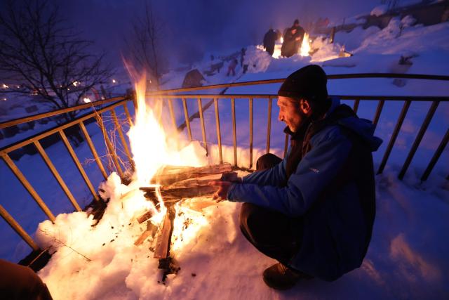 Georgians celebrate Lamproba, a traditional religious festival honouring the dead by burning fires at their graves, what is believed warming their souls, in the highland townlet of Mestia, located at an elevation of 1,500 metres (4,921 feet) in the Caucasus Mountains, in northwestern Georgia's Svaneti region on February 14, 2026. (Photo by Giorgi ARJEVANIDZE / AFP)