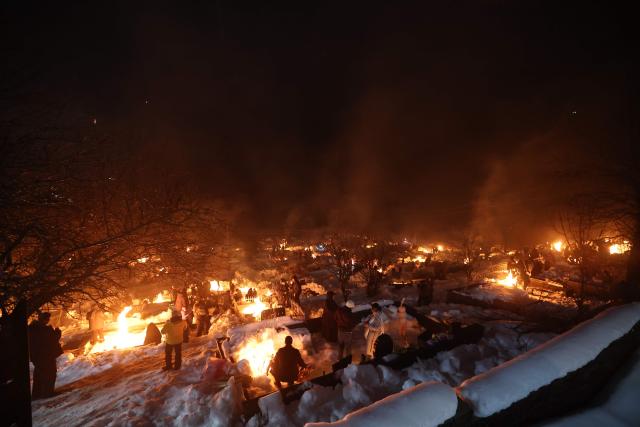 Georgians celebrate Lamproba, a traditional religious festival honouring the dead by burning fires at their graves, what is believed warming their souls, in the highland townlet of Mestia, located at an elevation of 1,500 metres (4,921 feet) in the Caucasus Mountains, in northwestern Georgia's Svaneti region on February 14, 2026. (Photo by Giorgi ARJEVANIDZE / AFP)
