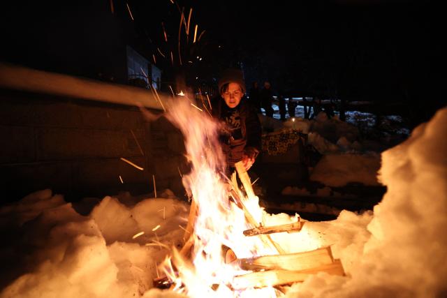 Georgians celebrate Lamproba, a traditional religious festival honouring the dead by burning fires at their graves, what is believed warming their souls, in the highland townlet of Mestia, located at an elevation of 1,500 metres (4,921 feet) in the Caucasus Mountains, in northwestern Georgia's Svaneti region on February 14, 2026. (Photo by Giorgi ARJEVANIDZE / AFP)