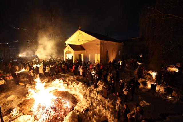 Georgians celebrate Lamproba, a traditional religious festival honouring the dead by burning fires at their graves, what is believed warming their souls, in the highland townlet of Mestia, located at an elevation of 1,500 metres (4,921 feet) in the Caucasus Mountains, in northwestern Georgia's Svaneti region on February 14, 2026. (Photo by Giorgi ARJEVANIDZE / AFP)