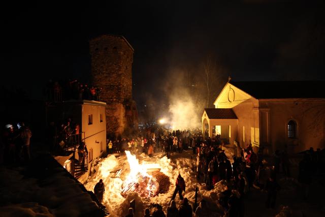 Georgians celebrate Lamproba, a traditional religious festival honouring the dead by burning fires at their graves, what is believed warming their souls, in the highland townlet of Mestia, located at an elevation of 1,500 metres (4,921 feet) in the Caucasus Mountains, in northwestern Georgia's Svaneti region on February 14, 2026. (Photo by Giorgi ARJEVANIDZE / AFP)