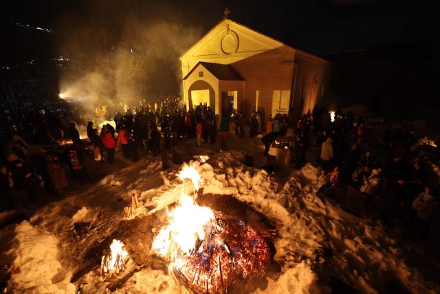 Georgians celebrate Lamproba, a traditional religious festival honouring the dead by burning fires at their graves, what is believed warming their souls, in the highland townlet of Mestia, located at an elevation of 1,500 metres (4,921 feet) in the Caucasus Mountains, in northwestern Georgia's Svaneti region on February 14, 2026. (Photo by Giorgi ARJEVANIDZE / AFP)
