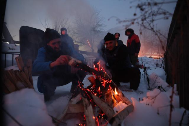 Georgians celebrate Lamproba, a traditional religious festival honouring the dead by burning fires at their graves, what is believed warming their souls, in the highland townlet of Mestia, located at an elevation of 1,500 metres (4,921 feet) in the Caucasus Mountains, in northwestern Georgia's Svaneti region on February 14, 2026. (Photo by Giorgi ARJEVANIDZE / AFP)