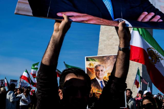 Demonstrators display an image of late Iranian Shah Mohammad Reza Pahlavi, who was overthrown in the 1979 Islamic Revolution, during a march in support of the people of Iran by members of the American-Iranian community in Washington, DC, on February 14, 2026. The demonstration comes after the bloody crackdown on protesters last month, while US President Donald Trump has been massing warships in the Middle East and declared Friday that a change of government in Iran would be the "best thing that could happen". (Photo by ROBERTO SCHMIDT / AFP)