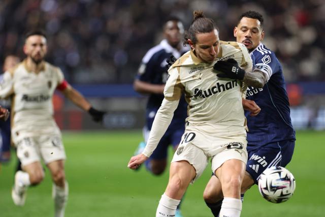 Lens' French forward #10 Florian Thauvin (2R) and Paris FC's French defender #15 Timothee Kolodziejczak (R) fight for the ball during the French L1 football match between Paris FC and RC Lens at the Stade Jean-Bouin in Paris on February 14, 2026. (Photo by ALAIN JOCARD / AFP)