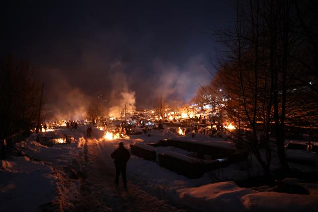 Georgians celebrate Lamproba, a traditional religious festival honouring the dead by burning fires at their graves, what is believed warming their souls, in the highland townlet of Mestia, located at an elevation of 1,500 metres (4,921 feet) in the Caucasus Mountains, in northwestern Georgia's Svaneti region on February 14, 2026. (Photo by Giorgi ARJEVANIDZE / AFP)