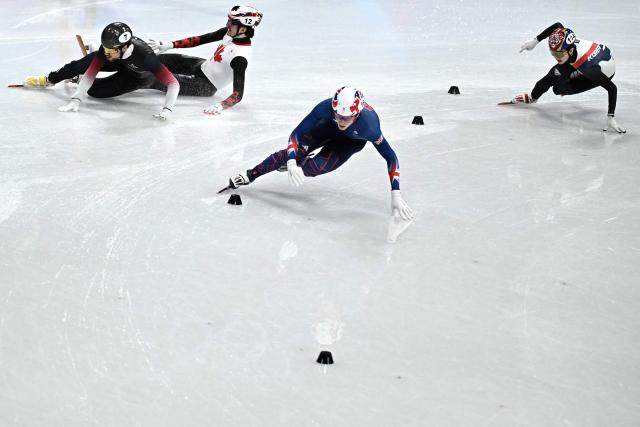 Canada's Felix Roussel (2L) and Latvia's Roberts Kruzbergs fall next to Britain's Niall Treacy (C) and South Korea's Shin Dong-min while competing in the short track speed skating men's 1500m semi-final during the Milano Cortina 2026 Winter Olympic Games at Milano Ice Skating Arena in Milan on February 14, 2026. (Photo by Gabriel BOUYS / AFP)