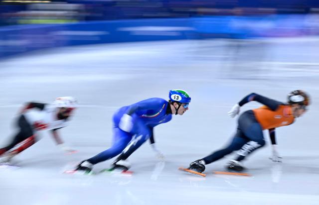 Italy's Thomas Nadalini (C), Canada's Steven Dubois (L) and Netherlands' Jens van 't Wout compete in the short track speed skating men's 1500m semi-final during the Milano Cortina 2026 Winter Olympic Games at Milano Ice Skating Arena in Milan on February 14, 2026. (Photo by WANG Zhao / AFP)