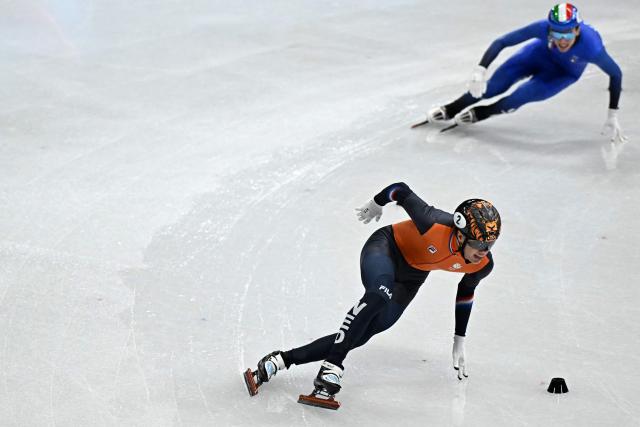Netherlands' Jens van 't Wout (bottom) and Italy's Thomas Nadalini compete in the short track speed skating men's 1500m semi-final during the Milano Cortina 2026 Winter Olympic Games at Milano Ice Skating Arena in Milan on February 14, 2026. (Photo by Gabriel BOUYS / AFP)