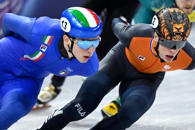 Italy's Thomas Nadalini (L) and Netherlands' Jens van 't Wout compete in the short track speed skating men's 1500m semi-final during the Milano Cortina 2026 Winter Olympic Games at Milano Ice Skating Arena in Milan on February 14, 2026. (Photo by WANG Zhao / AFP)