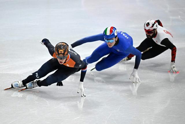 (L-R) Netherlands' Jens van 't Wout, Italy's Thomas Nadalini and Canada's Steven Dubois compete in the short track speed skating men's 1500m semi-final during the Milano Cortina 2026 Winter Olympic Games at Milano Ice Skating Arena in Milan on February 14, 2026. (Photo by Gabriel BOUYS / AFP)