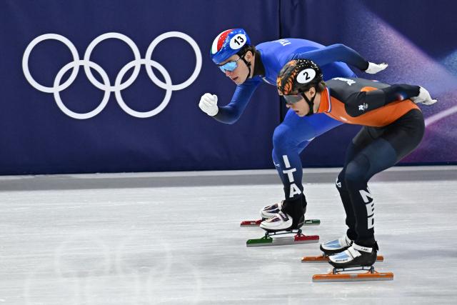 Italy's Thomas Nadalini (L) and Netherlands' Jens van 't Wout compete in the short track speed skating men's 1500m semi-final during the Milano Cortina 2026 Winter Olympic Games at Milano Ice Skating Arena in Milan on February 14, 2026. (Photo by Gabriel BOUYS / AFP)