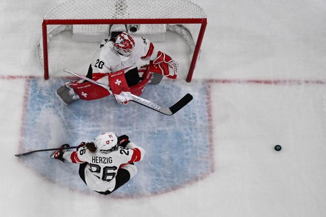 Switzerland's #26 Naemi Herzig (down L) and Switzerland's #20 Andrea Braendli (up L) eye the puck during the women's quarter final ice hockey match between Finland and Switzerland at the Milano Rho Ice Hockey Arena at the Milano Cortina 2026 Winter Olympic Games in Milan, on February 14, 2026. (Photo by Alexander NEMENOV / AFP)