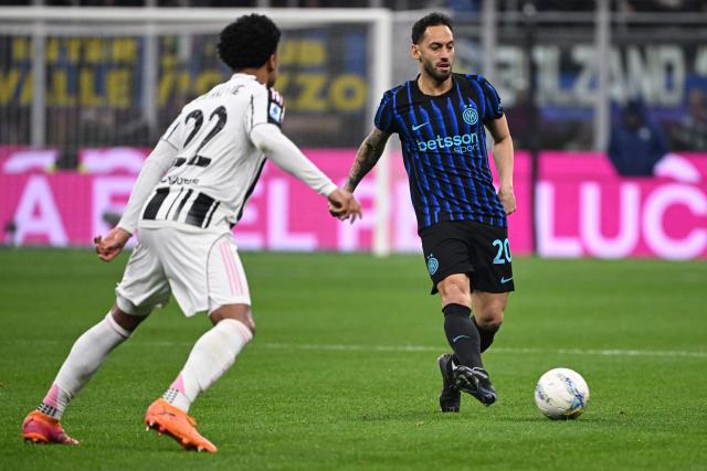 Juventus' US midfielder #22 Weston McKennie (R) fights for the ball with Inter Milan's Turkish midfielder #20 Hakan Calhanoglu during the Italian Serie A football match between Inter Milan and Juventus at the San Siro Stadium in Milan, on February 14, 2026. (Photo by Piero CRUCIATTI / AFP)