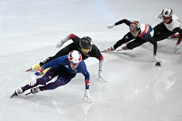 (L-R) Britain's Niall Treacy, Latvia's Roberts Kruzbergs, South Korea's Shin Dong-min and Canada's Felix Roussel compete in the short track speed skating men's 1500m semi-final during the Milano Cortina 2026 Winter Olympic Games at Milano Ice Skating Arena in Milan on February 14, 2026. (Photo by Gabriel BOUYS / AFP)