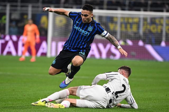 Inter Milan's Argentinian forward #10 Lautaro Martinez (L) leaps over a tackle from Juventus' Swedish defender #02 Emil Holm (R) during the Italian Serie A football match between Inter Milan and Juventus at the San Siro Stadium in Milan, on February 14, 2026. (Photo by Piero CRUCIATTI / AFP)
