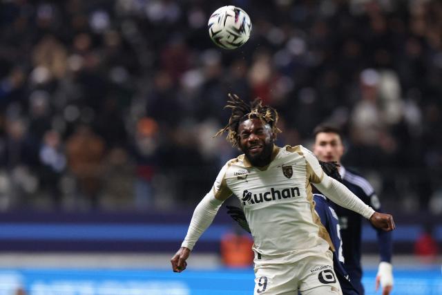Lens' French forward #09 Allan Saint-Maximin (L) heads the ball during the French L1 football match between Paris FC and RC Lens at the Stade Jean-Bouin in Paris on February 14, 2026. (Photo by ALAIN JOCARD / AFP)