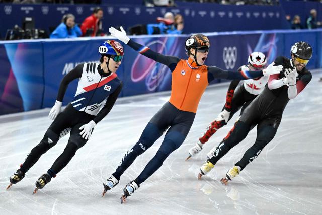 Netherlands' Jens van 't Wout (C) celebrates as he crosses the finish line to win gold in the short track speed skating men's 1500m final during the Milano Cortina 2026 Winter Olympic Games at Milano Ice Skating Arena in Milan on February 14, 2026. (Photo by WANG Zhao / AFP)