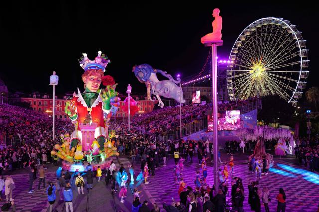 People look at a giant picture depicting a King during the opening parade of the 141th edition of the Nice Carnival in the French Riviera City of Nice on February 14, 2026. (Photo by Valery HACHE / AFP)