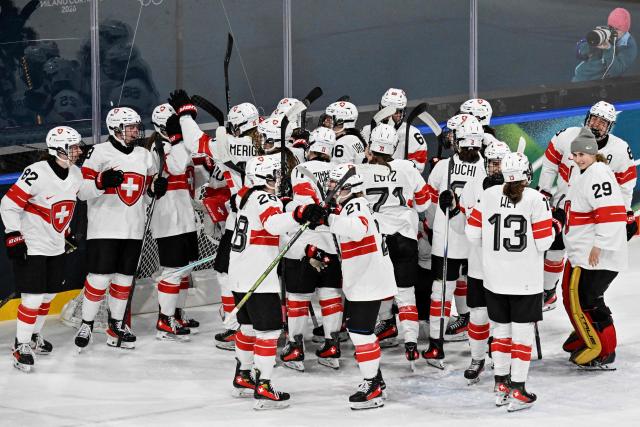 Switzerland's teammates celebrate after winning at the end of the women's quarter final ice hockey match between Finland and Switzerland at the Milano Rho Ice Hockey Arena at the Milano Cortina 2026 Winter Olympic Games in Milan, on February 14, 2026. Switzerland wins 1 - 0 against Finland and qualifies for the semi-finals. (Photo by Alexander NEMENOV / AFP)