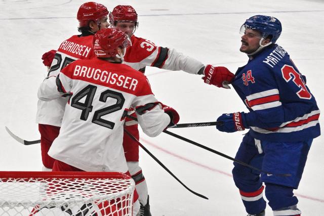 USA's #34 Auston Matthews (R) has an altercation with Denmark's #42 Phillip Bruggisser and team mates during the men's preliminary round Group C Ice Hockey match between USA and Denmark at the Milano Santagiulia Ice Hockey Arena during the Milano Cortina 2026 Winter Olympic Games in Milan, on February 14, 2026. (Photo by JULIEN DE ROSA / POOL / AFP)