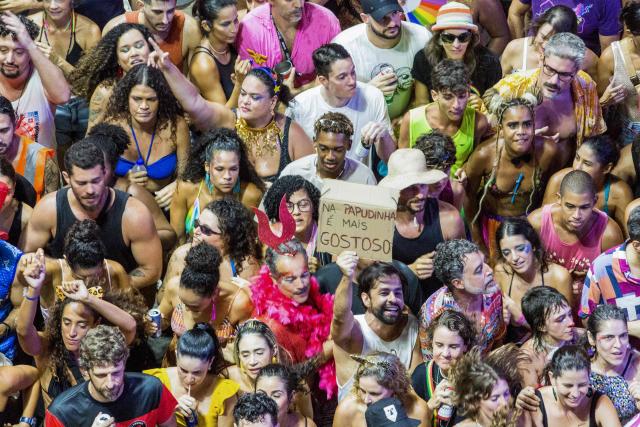 Revelers enjoy during the BaianaSystem carnival group parade in Salvador, Bahia, Brazil on February 14, 2026. BaianaSystem revolutionized Bahian music by blending the traditional Bahian guitar with the aesthetics of Jamaican sound systems, Afro-Brazilian rhythms (afoxé, ijexá, samba-reggae), and electronic music. (Photo by Antonello Veneri / AFP)