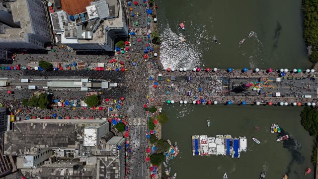 This aerial view shows revelers taking part in the Galo da Madrugada (Dawn Rooster) carnival band parade on the streets of Recife, Brazil on February 14, 2026. (Photo by Carlos FABAL / AFP)