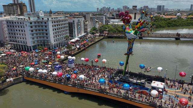 This aerial view shows revelers taking part in the Galo da Madrugada (Dawn Rooster) carnival band parade on the streets of Recife, Brazil on February 14, 2026. (Photo by Carlos FABAL / AFP)