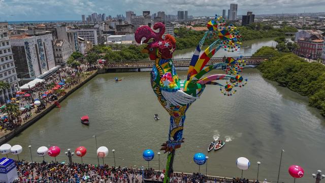This aerial view shows revelers taking part in the Galo da Madrugada (Dawn Rooster) carnival band parade on the streets of Recife, Brazil on February 14, 2026. (Photo by Carlos FABAL / AFP)