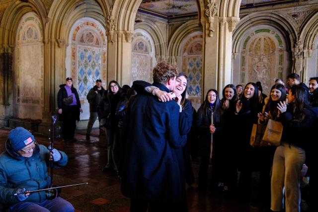 A couple dances next to a street musician in Central Park on Valentine’s day in New York, on February 14, 2026. (Photo by Charly TRIBALLEAU / AFP)