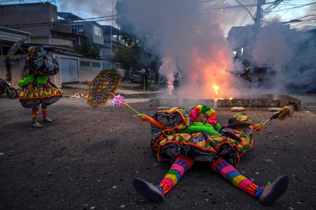 Revelers perform during the parade of Dito e Feito bate-bola street carnival group at Iraja neighbourhood, in the suburbs of Rio de Janeiro, Brazil on February 14, 2026. (Photo by Mauro PIMENTEL / AFP)