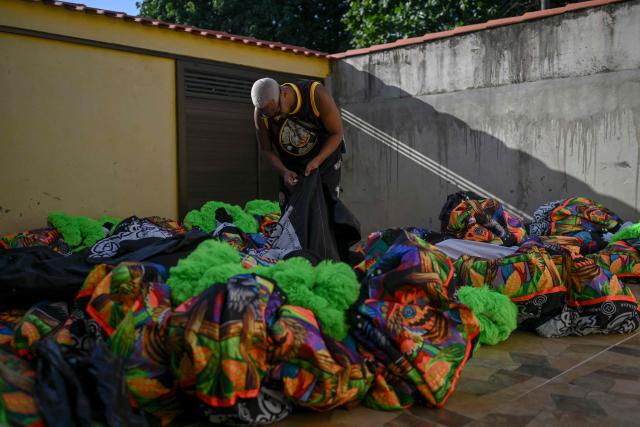 Members of Dito e Feito bate-bola street carnival group get ready to parade at Iraja neighbourhood, in the suburbs of Rio de Janeiro, Brazil on February 14, 2026. (Photo by MAURO PIMENTEL / AFP)