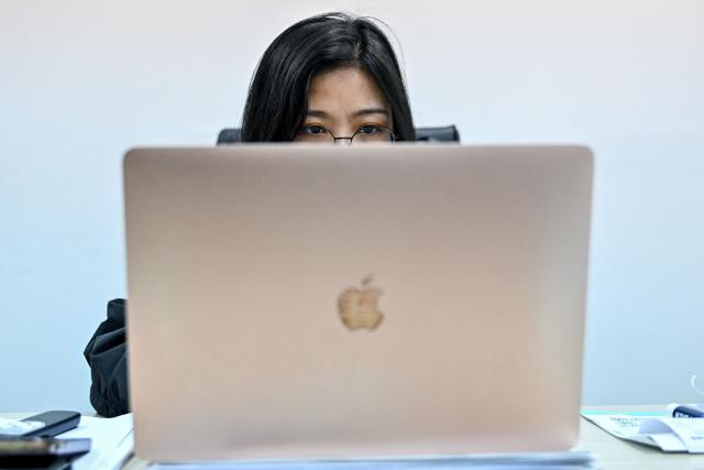 This photo taken on February 12, 2026 shows a Vietnamese cryptocurrency investor looking at the latest Bitcoin values on a laptop in Hanoi. As a first-year computer science student in Hanoi, Hoang Le started trading crypto from his university dorm room, egged on by his gamer friends who were making a killing, and at one point his digital holdings swelled to $200,000 -- around 50 times the average annual income in Vietnam. But they crashed to zero when the bottom fell out of bitcoin and other cryptocurrencies in recent months. (Photo by Nhac NGUYEN / AFP) / To go with 'VIETNAM-ECONOMY-CRYPTO,FOCUS' by Lam NGUYEN